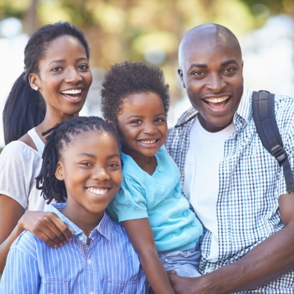 Family of four smiling outdoors