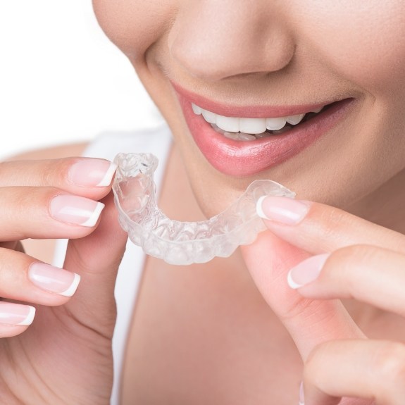 Close up of person putting aligner in her mouth