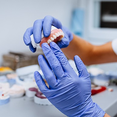 A lab technician holding a custom denture