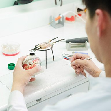 A dental technician slowly making dentures