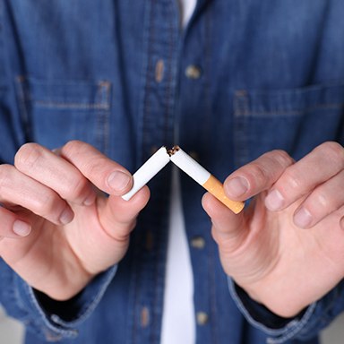 Closeup of person breaking cigarette