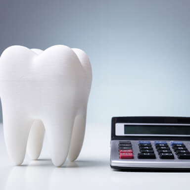 a model tooth next to a calculator 