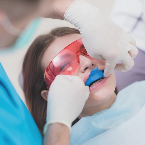 Young woman getting fluoride treatment in dental office